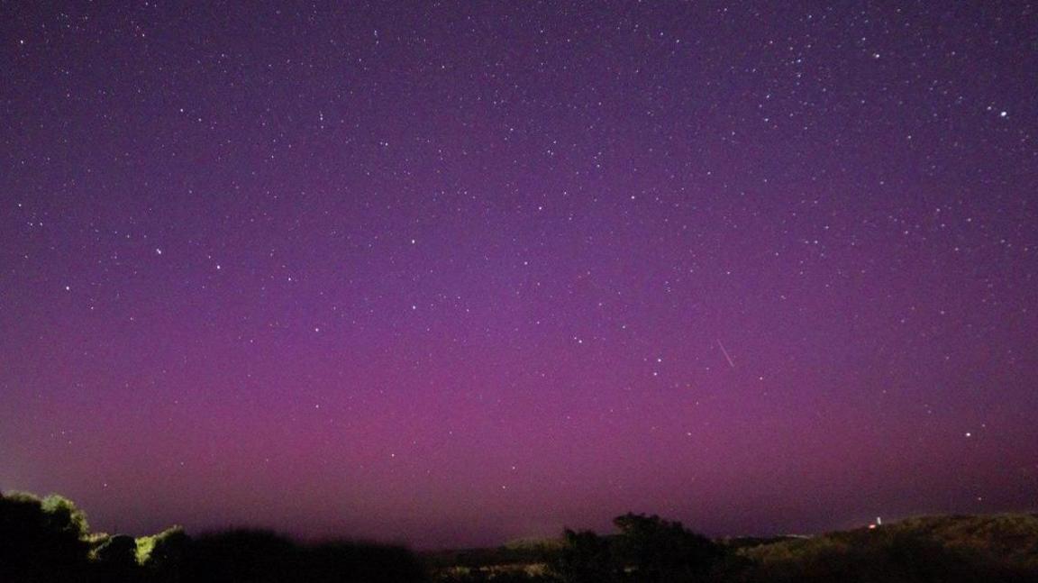 Shooting star and stars in aurora sky