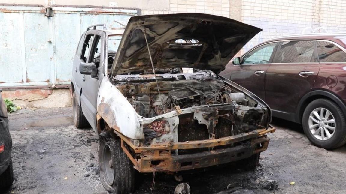 A bombed-out car with its bonnet open