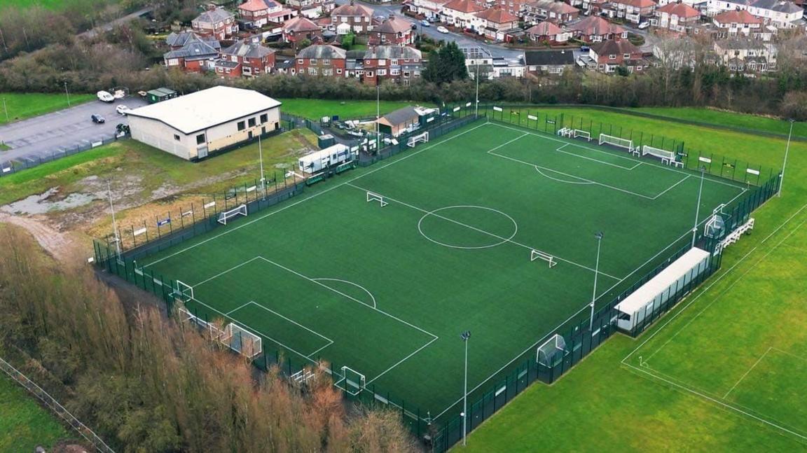 Aerial view of a football pitch and sports hall