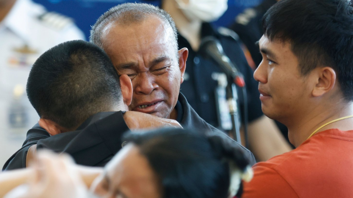 Thai hostage Pongsak Thaenna (L), who was taken in the attack led by the Palestinian militant group Hamas on 07 October 2023, is embraced by his father (C) next to his younger brother