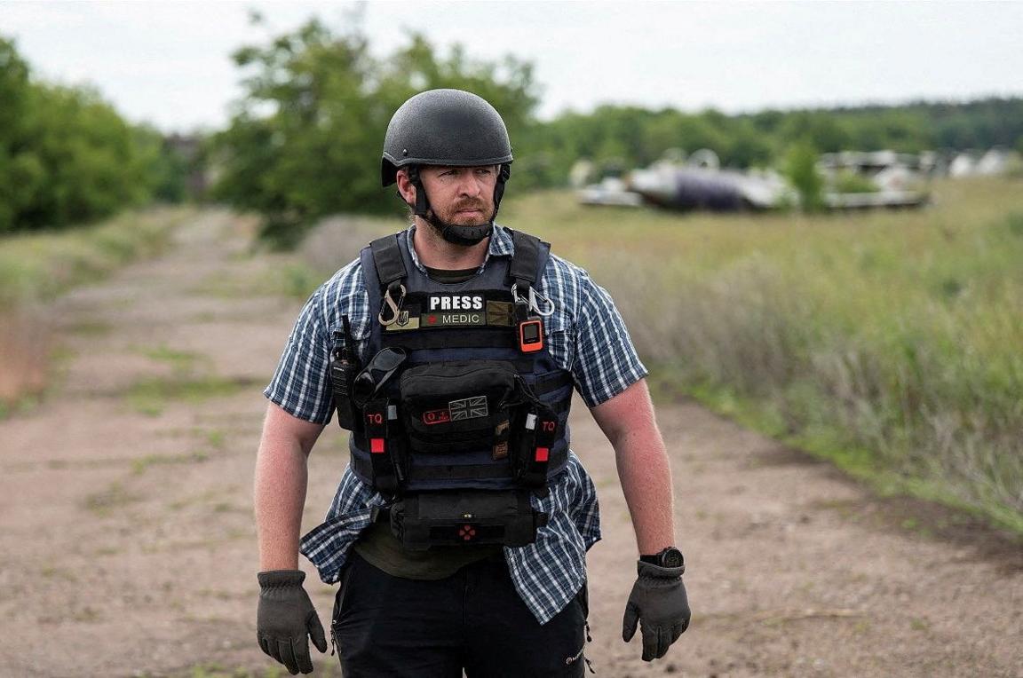 Reuters safety advisor Ryan Evans stands in a field while working with a news reporting team in an undated photo taken in Ukraine