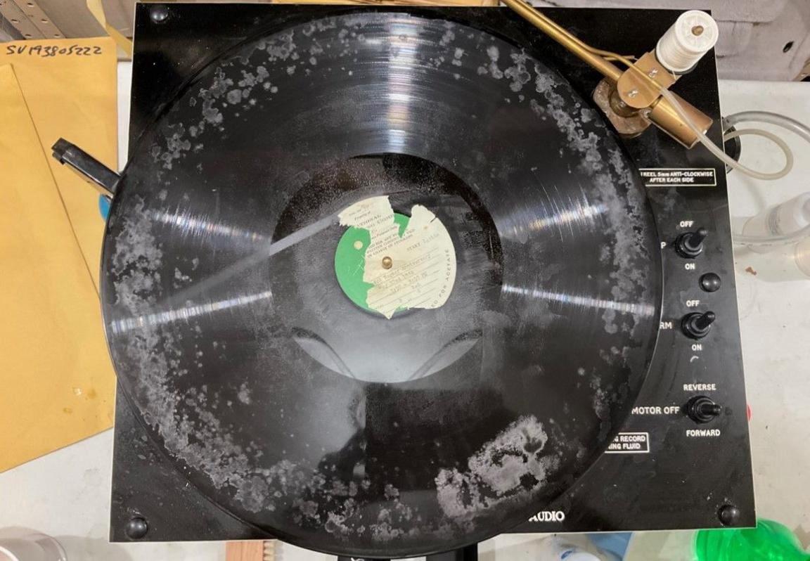 An old disc on top of a playing facility. Paper is on the left of the photo.