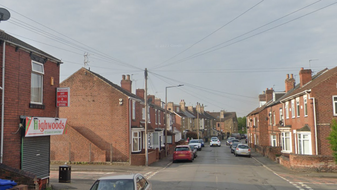 View looking down Highwoods Road in Mexborough - with a corner shop on the left and terraced housing receding into the distance