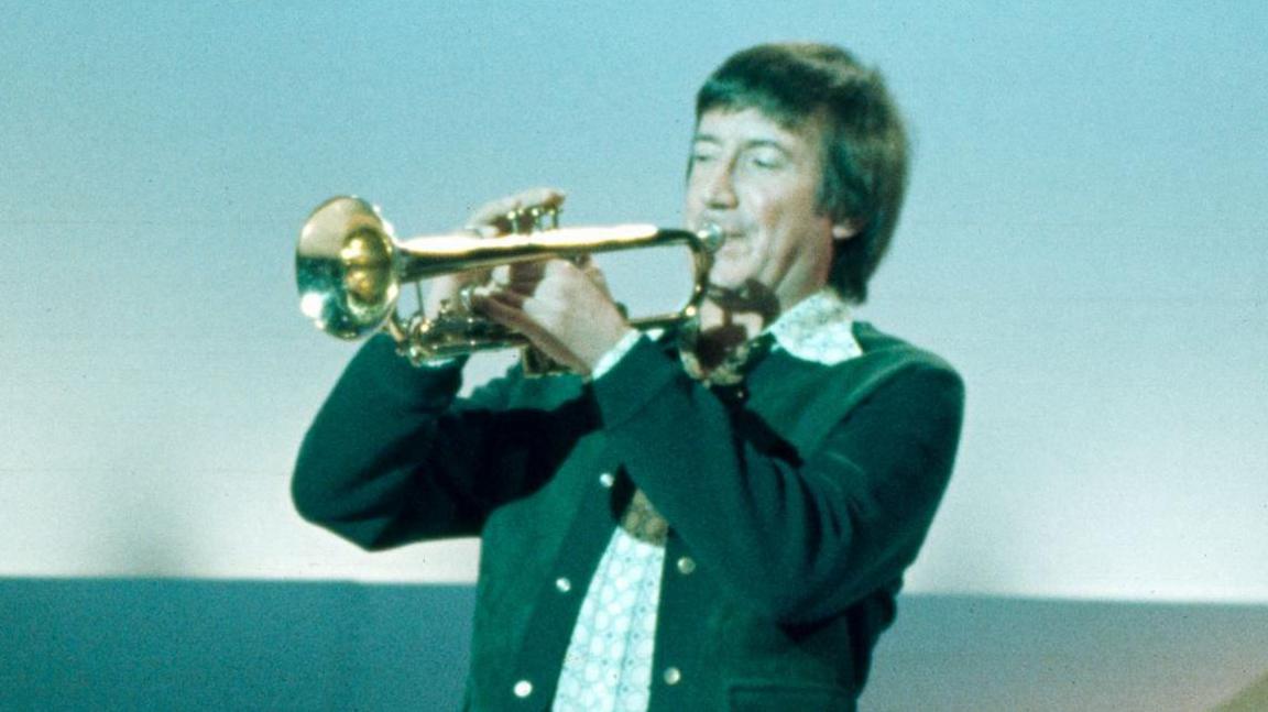 Roy Castle playing trumpet on a BBC TV set in February 1976