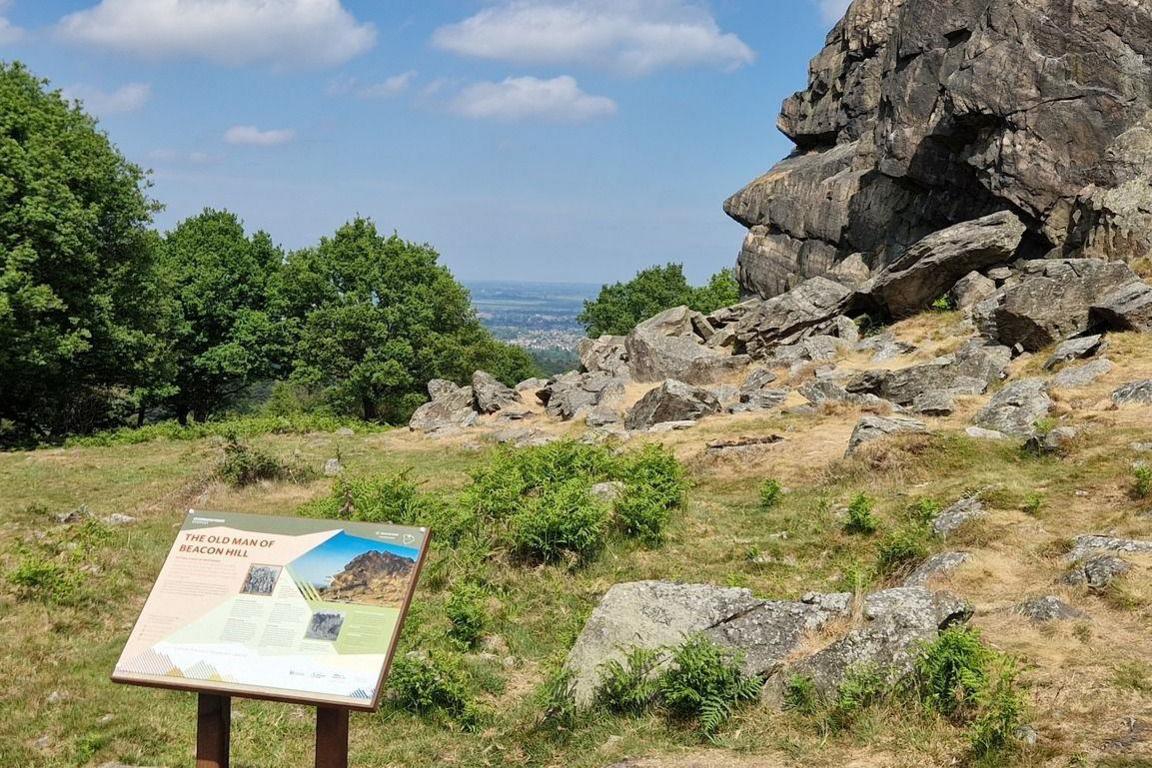 Information panel in front of a rock formation called The Old Man of Beacon Hill