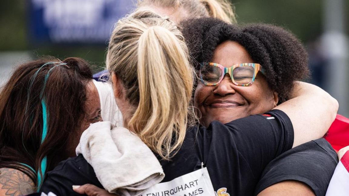 A group of athletes hug each other after competing in events in the World Female Heavy Events Championship in Drumnadrochit.
