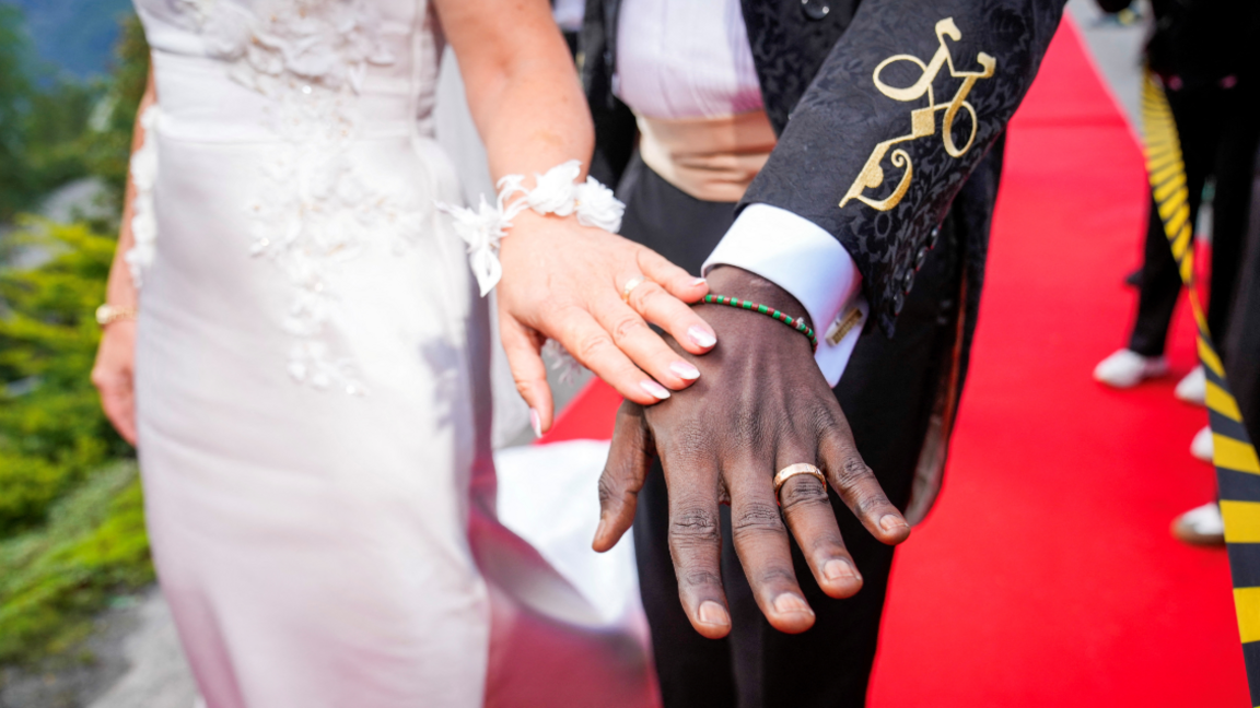 Norway's Princess Martha Louise and Durek Verrett show their wedding rings and an entwined "M" and "D" embroidered in gold on Mr Verrett's suit sleeve