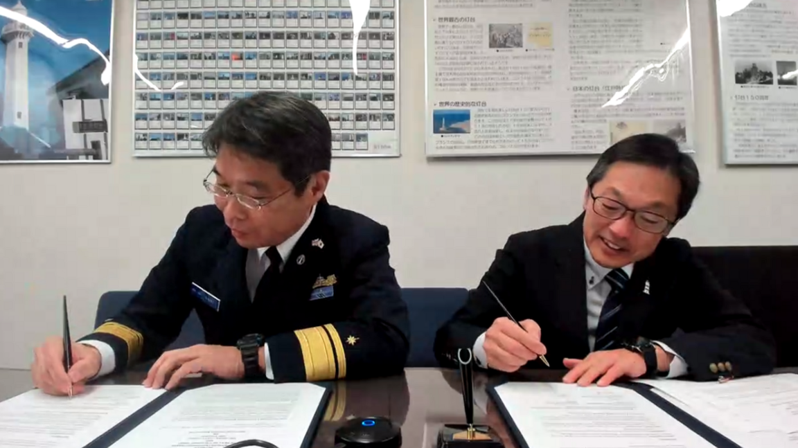 Two men from the Japanese coastguard put pen to paper on a twinning agreement with a Scottish lighthouse