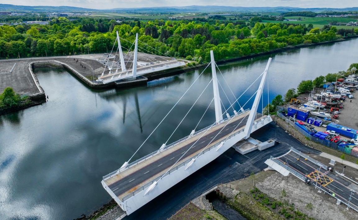 A large white bridge, with the two sections moved parallel to the bank so that there is a large gap where ships can pass