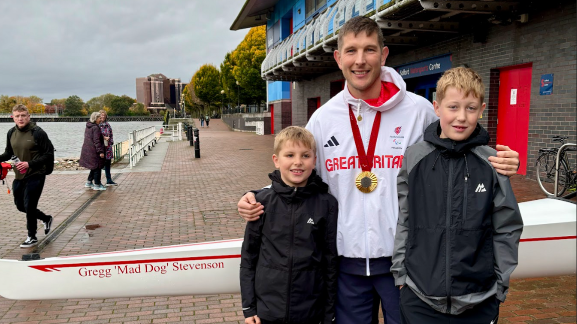 Gregg and his two sons pose with the boat named in Gregg's honour 