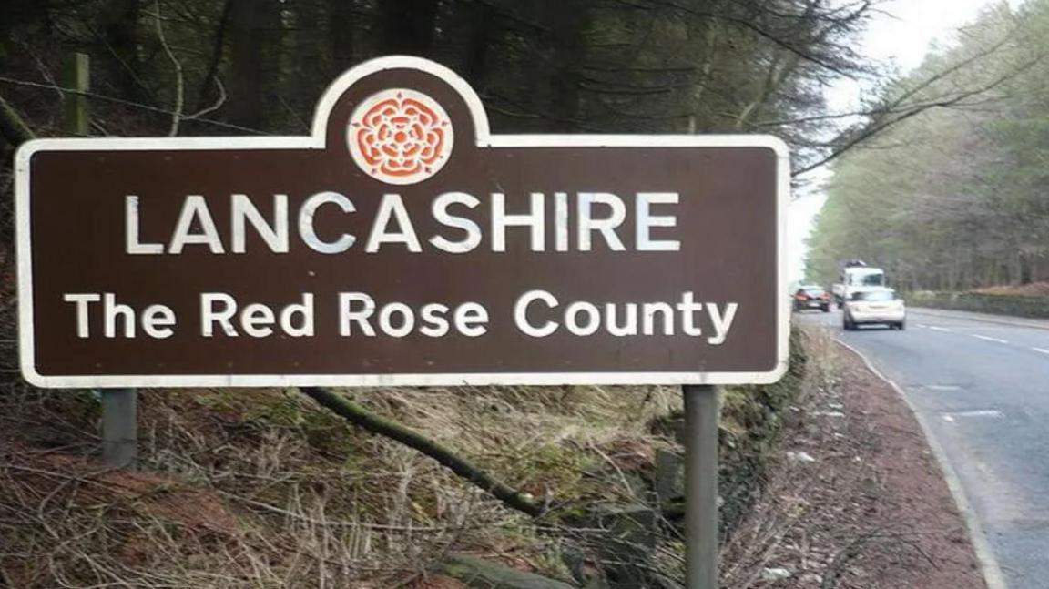 Road sign which marks the start of the county of Lancashire which reads: 'Lancashire The Red Rose County'