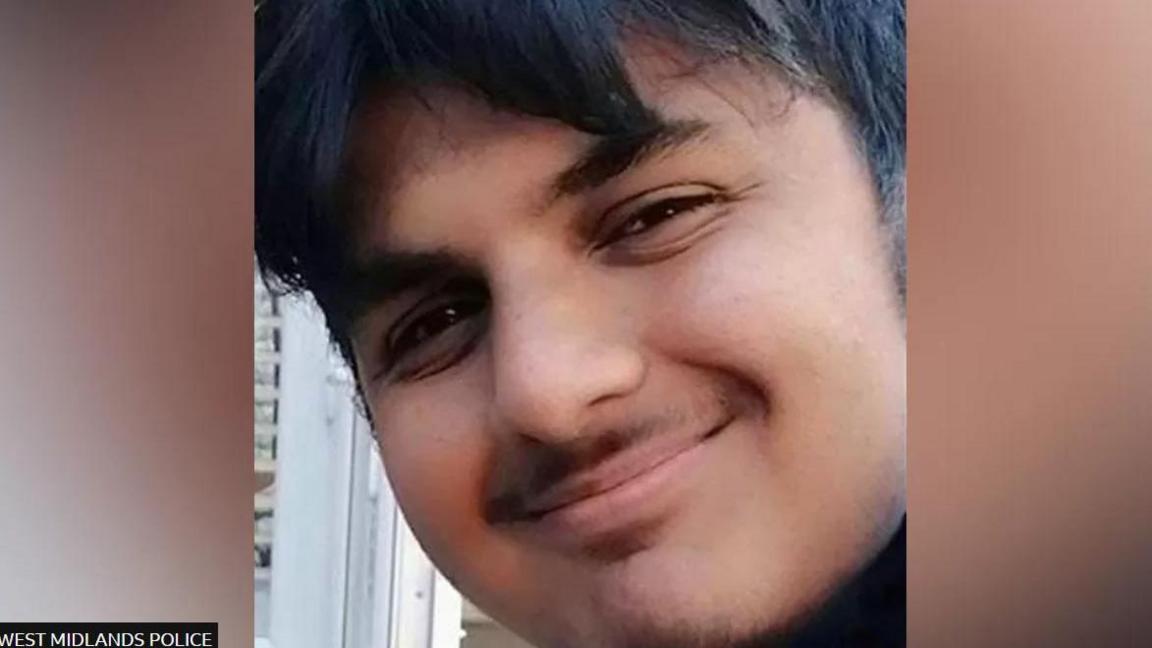 A young boy smiling with dark hair