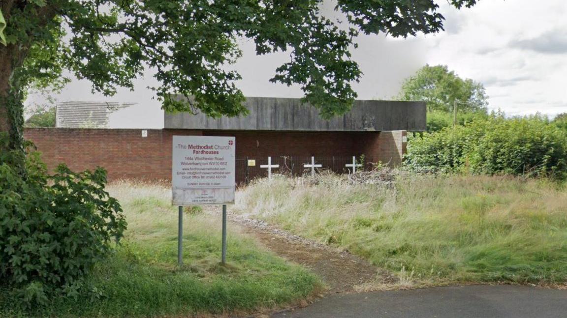 A derelict building with three white crosses outside and a sign at the front that says "The Methodist Church, Fordhouses". 