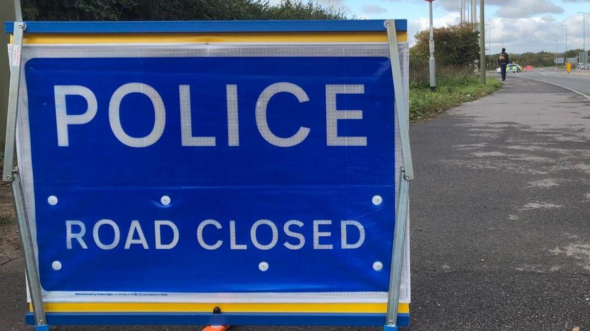 A police road closed sign