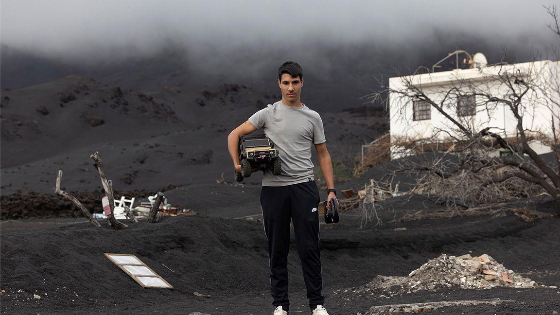 Boy stands holding remote car surrounded by lava 