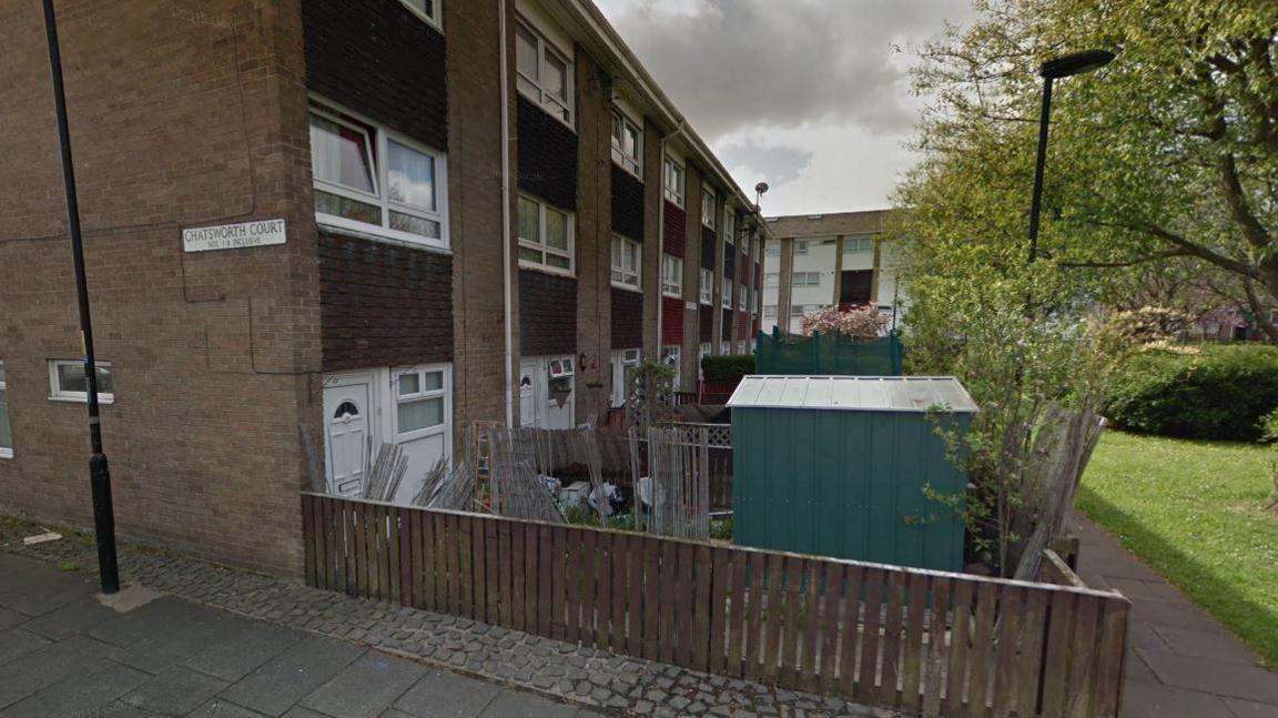 A view of Chatsworth Court. The street sign can be seen attached to a row of terraced houses.