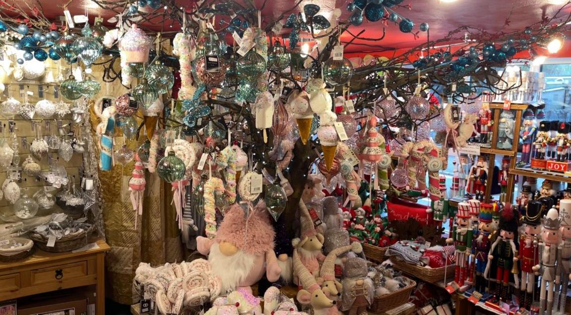 The inside of a shop covered in colourful Christmas decorations