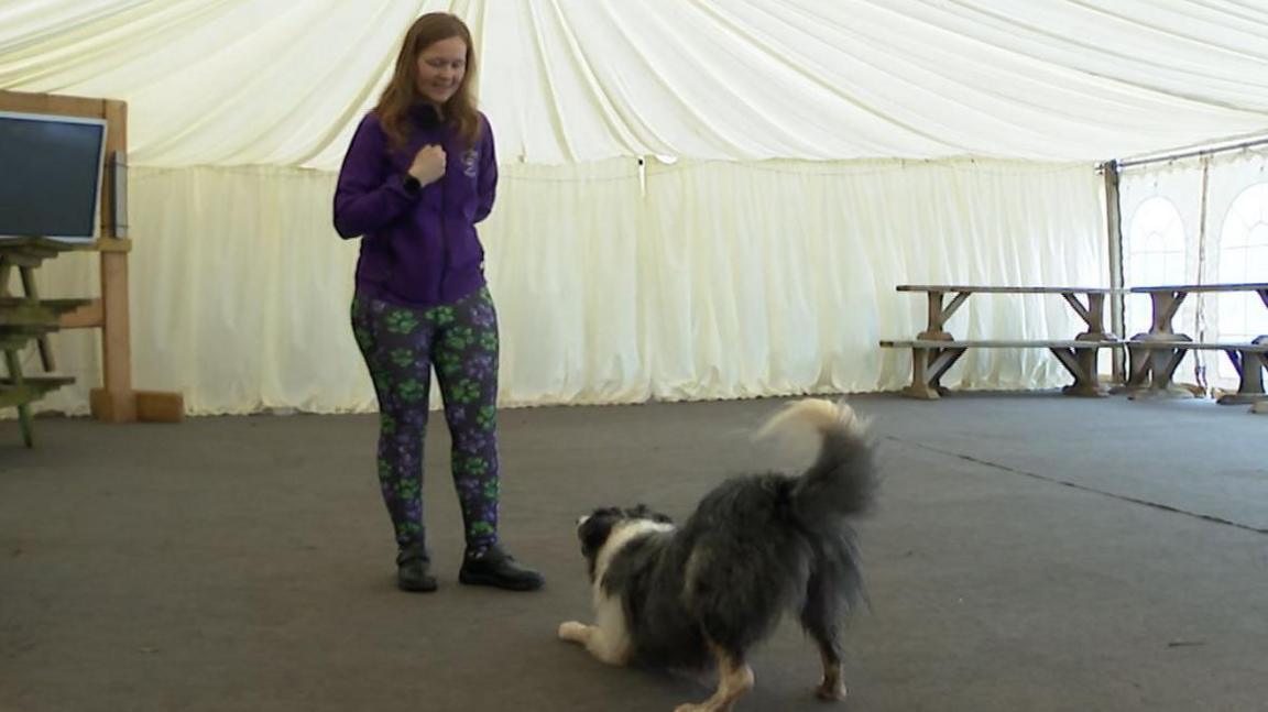 Lorna standing over Nora while she is going through part of her routine. 