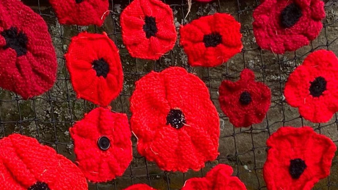 Poppies on netting in front of the church building.