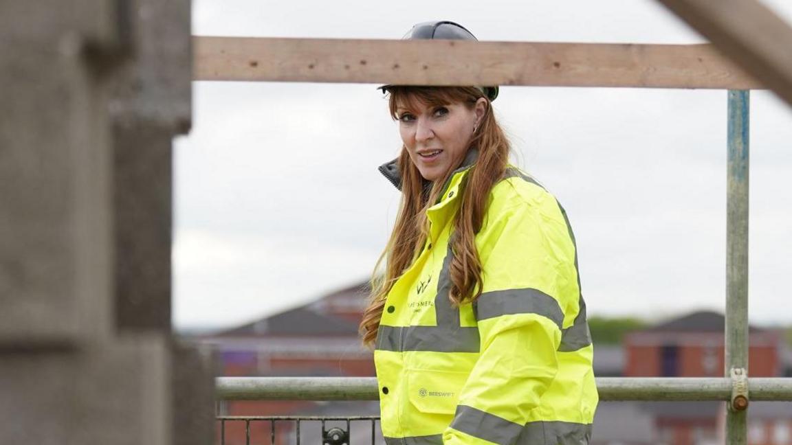 Deputy Prime Minister Angela Rayner on a building site in Derby. She is wearing a hi-vis jacket and a hard hat.