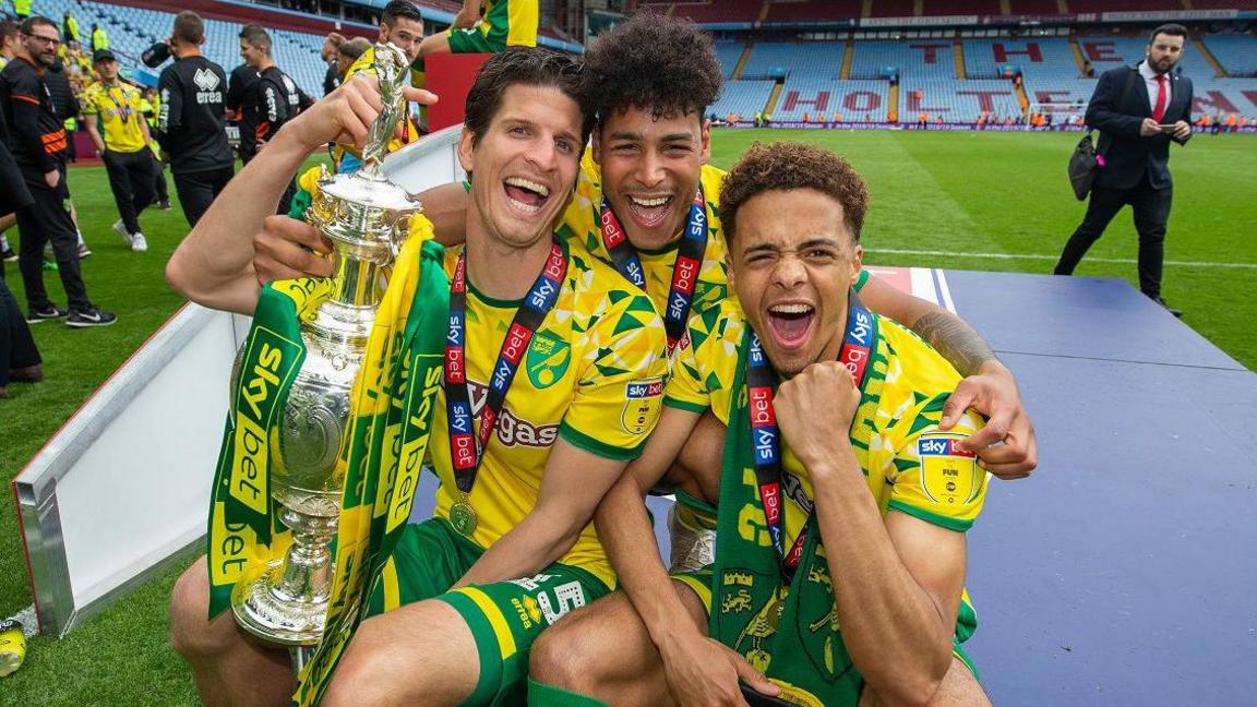 Onel Hernandez (centre) alongside Timm Klose and Jamal Lewis and the 2018-19 Championship trophy