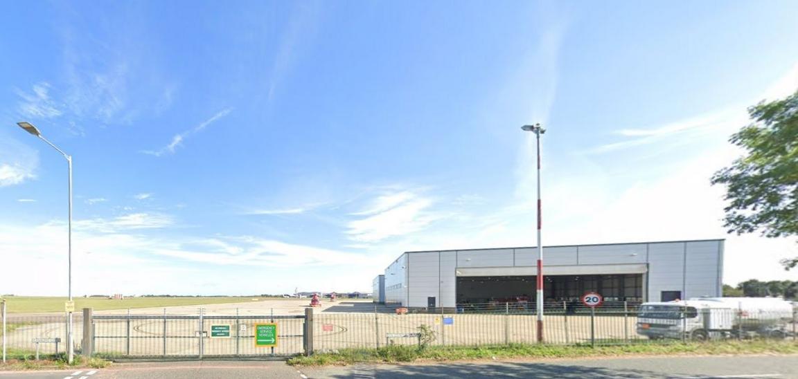 Airport perimeter fence showing gate and lampposts