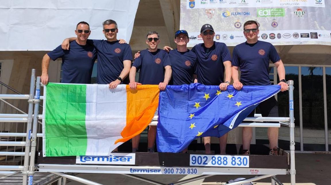 Dublin firefighters pose with an Irish flag at the event in Seville