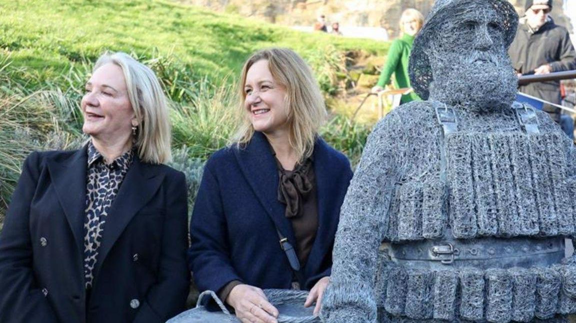 Lesley Jackson (L) and Emma Stothard (R) next to the wire statue