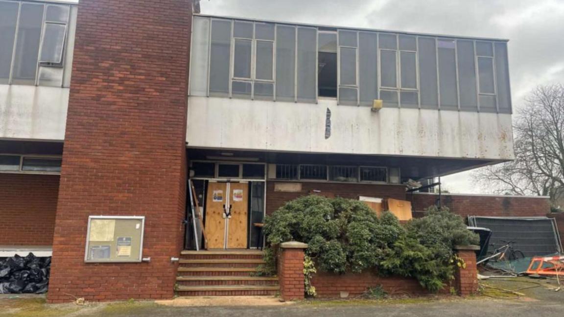 Rushden Police Station looking run down with derelict paint and debris surrounding the building. 