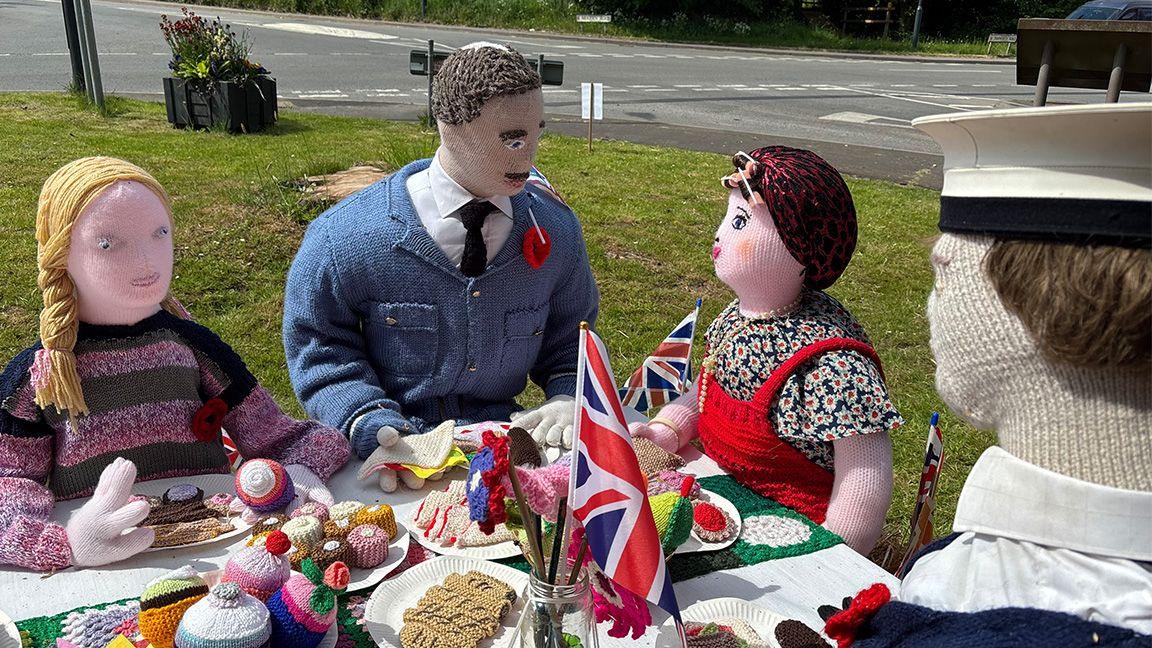 Crocheted people and food in a tea party setting
