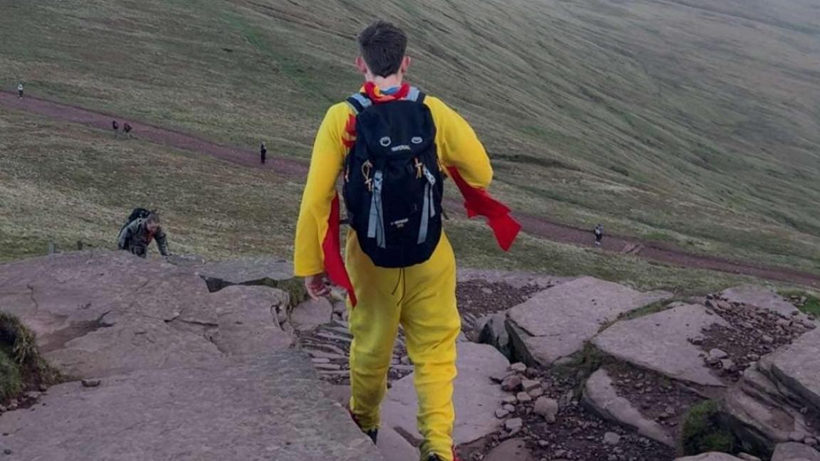 Luke trekking across a mountain in his costume.