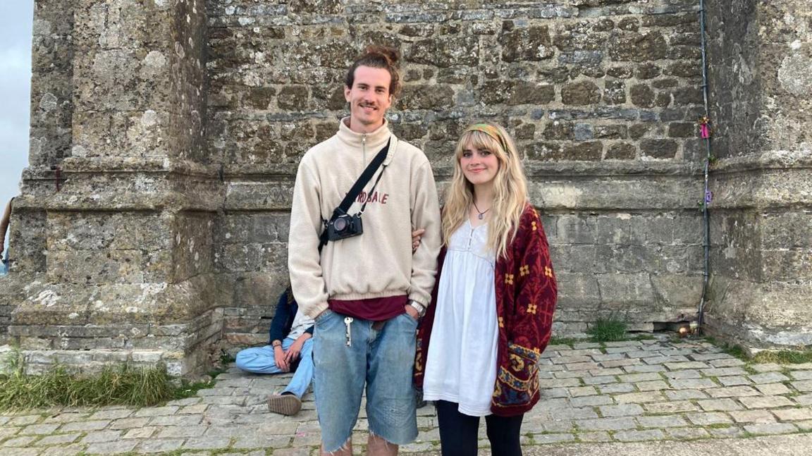 Melissa and James standing in front of the Glastonbury Tor 