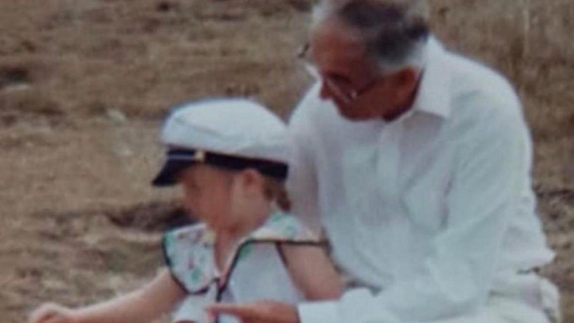 Katie pictured on a beach alongside her grandfather 