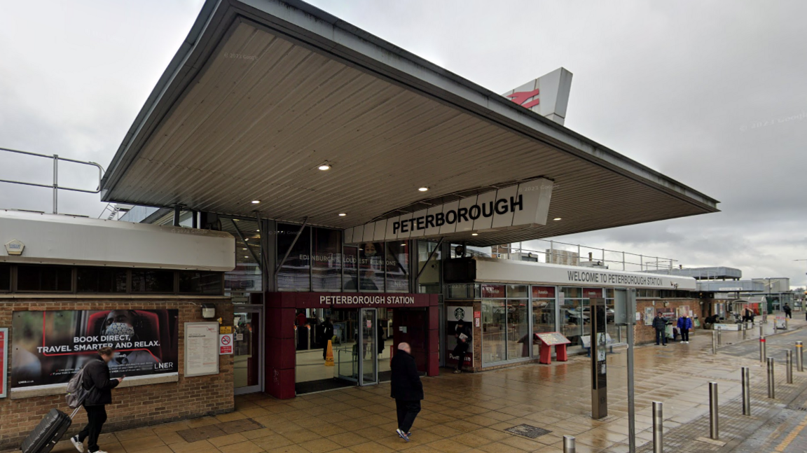 Peterborough train station entrance with a red door frame with Peterborough written on it 