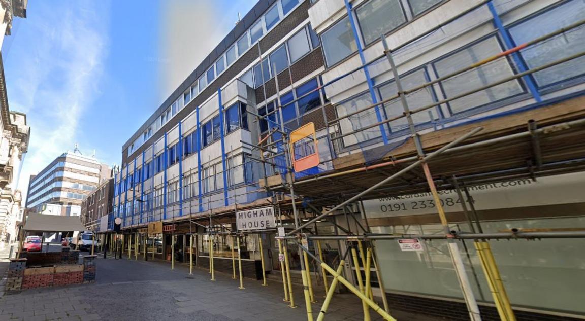 Streetview of Higham House. It is large brutalist looking building with scaffolding across its front.