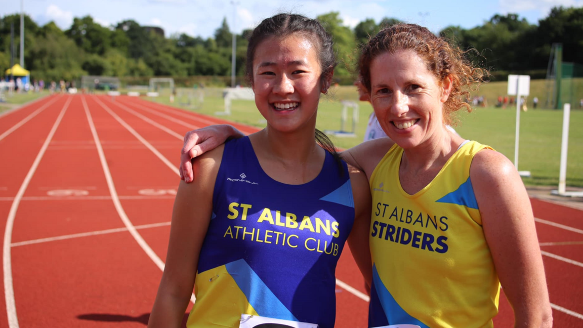 Two members of the athletic club standing on the track