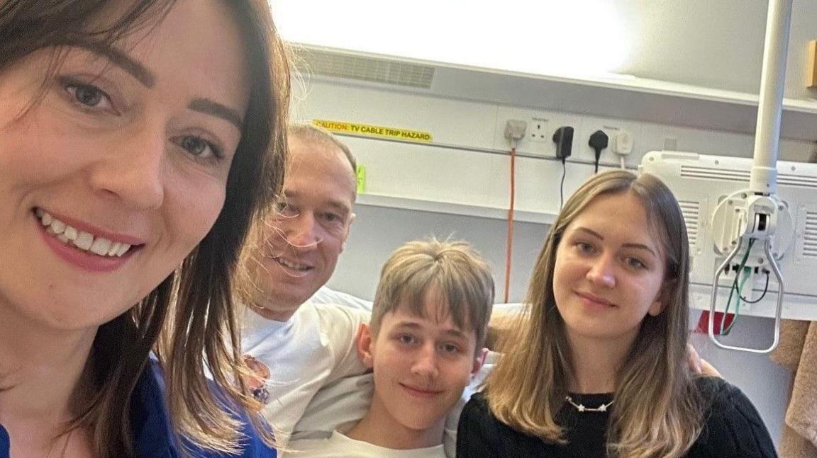 Alan with his family in the hospital