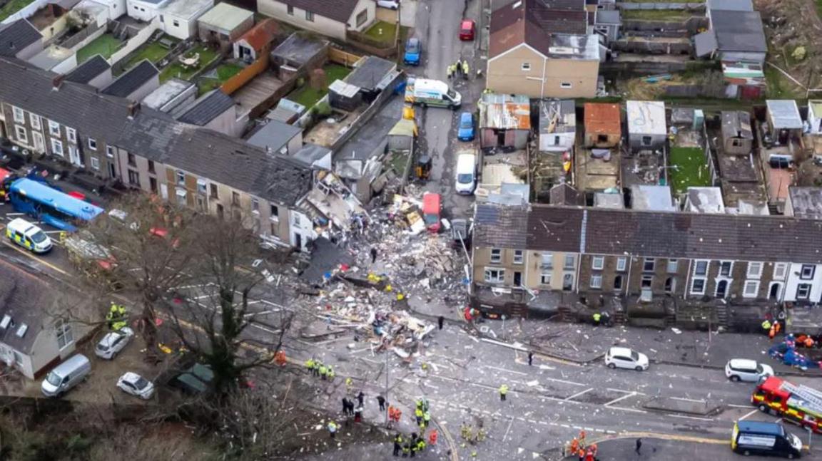 An aerial view of a row of terraced houses, with one completely destroyed in the middle