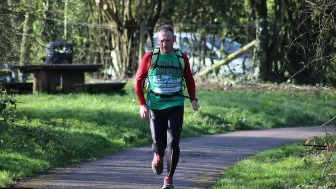 Gary McKee runs outside on a path on a sunny day.