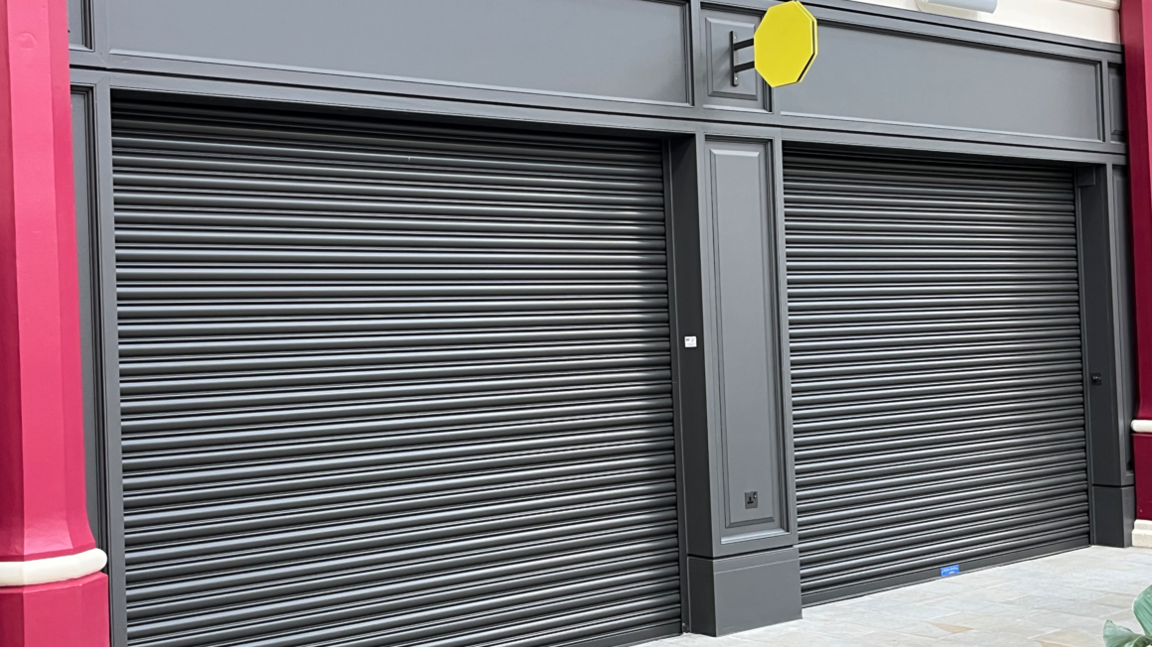 Empty units with shutters down inside Derby Market Hall
