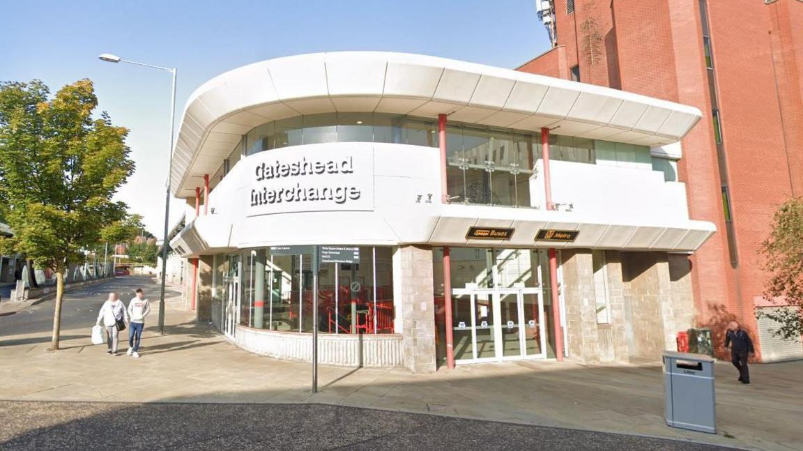 Streetview of the entrance to the Gateshead Interchange, which contains a bus and Metro station. It is a two storey building with lots of glazing and a curved frontage