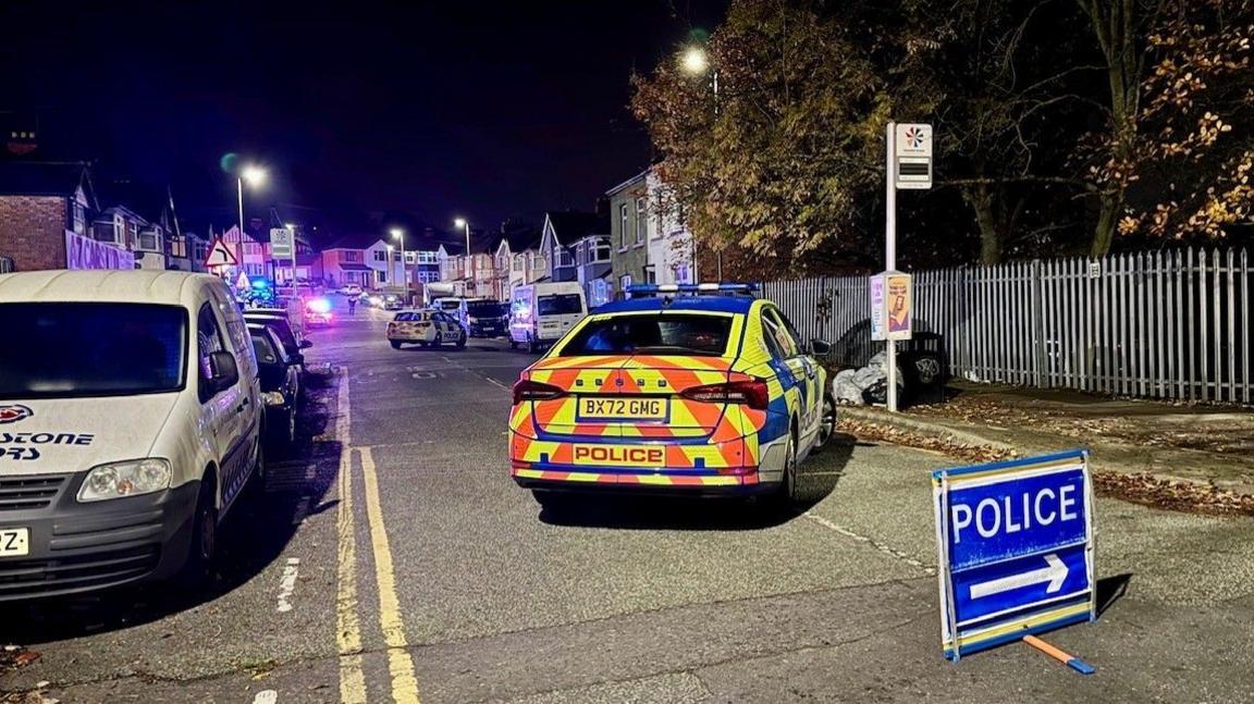 The scene in St Saviours Road in Leicester. Two police cars can be seen at the scene as a diversion road sign.