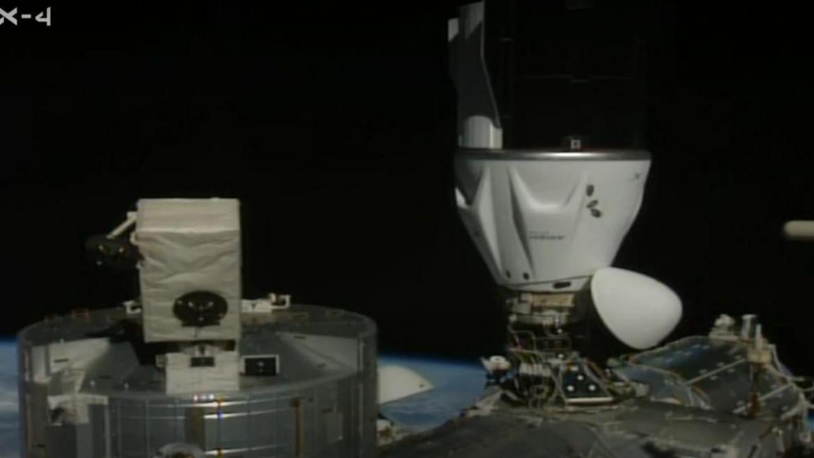 The image is of the Dragon spacecraft connected to the ISS.