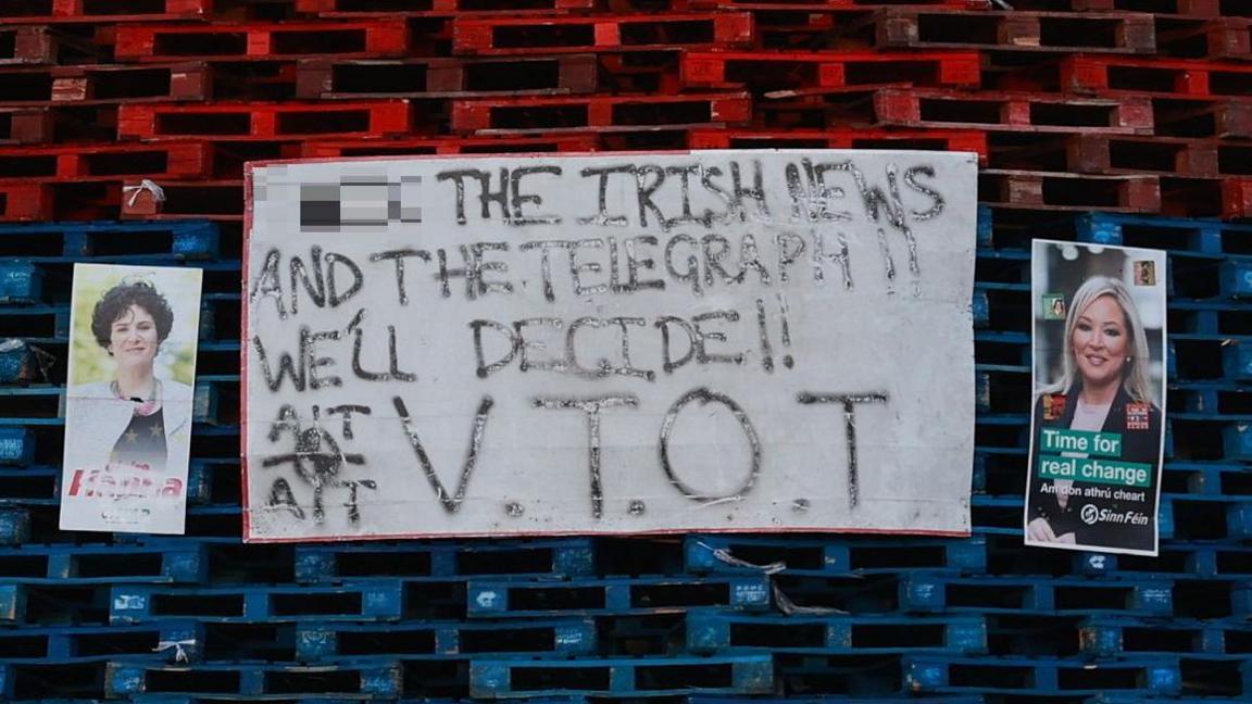 Claire Hanna and Michelle O'Neill election posters on a bonfire in south Belfast