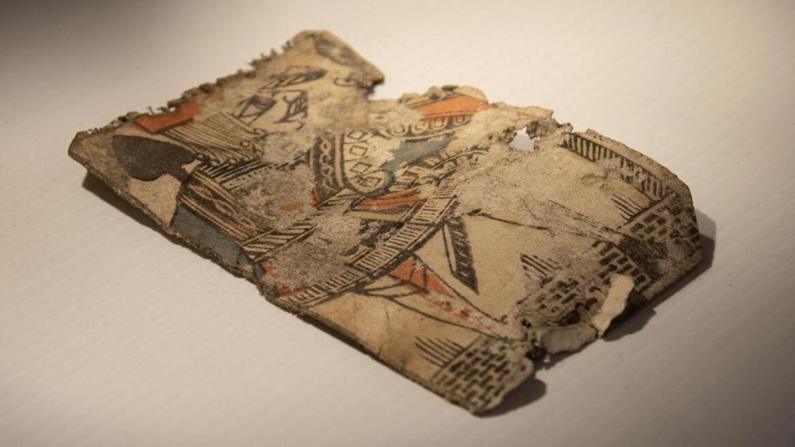 A 300 year old Jack of Spades playing card with damaged corners and edges