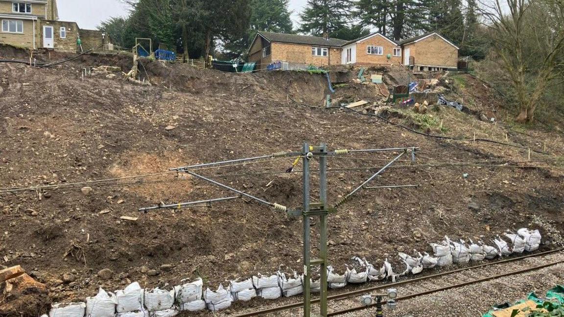 A photo of sandbags being used to shore up the landslip next to the railway line at Baildon