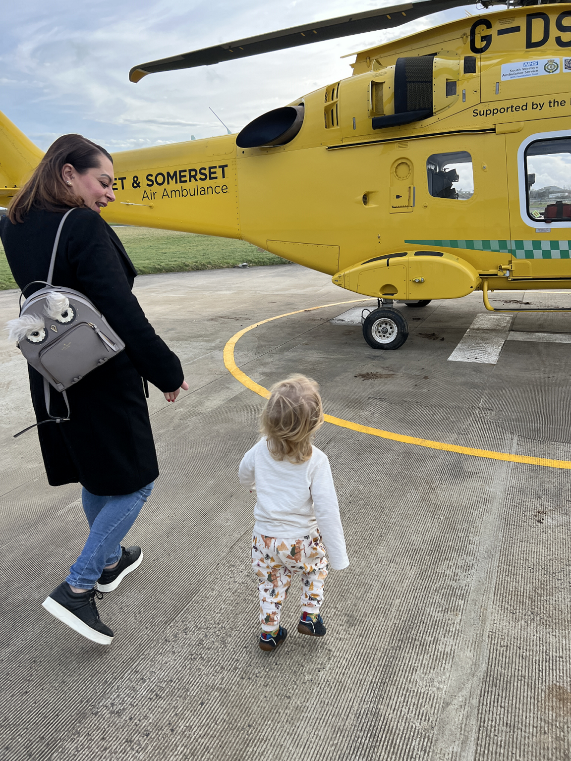 Shelley Masefield and Leo walking towards a yellow DSAA on a runway like the one that would have been used to transport Miss Masefield 