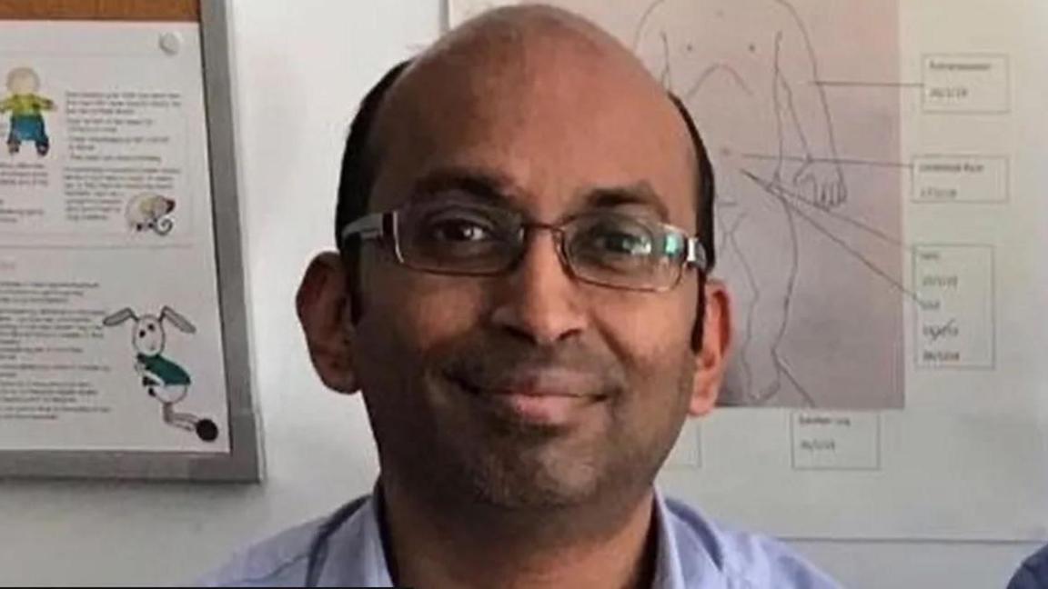 A head and shoulders shot of Dr Shree Vishna Rasiah, wearing a blue shirt and glasses