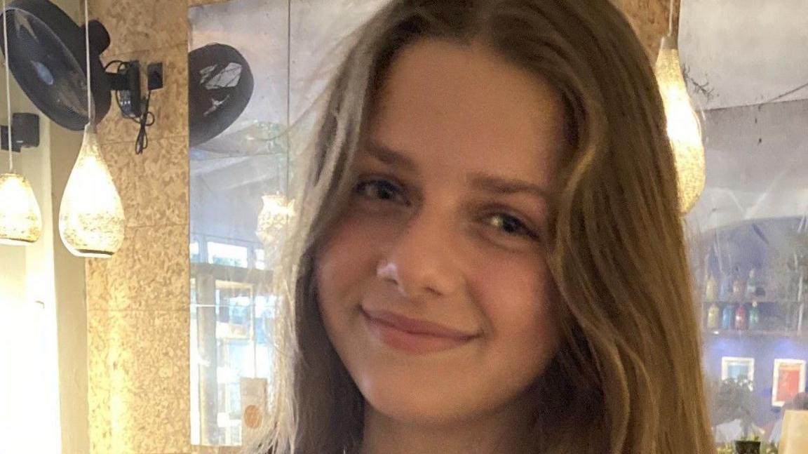 A photo of Eleanor Hague. She has long light brown hair and is smiling