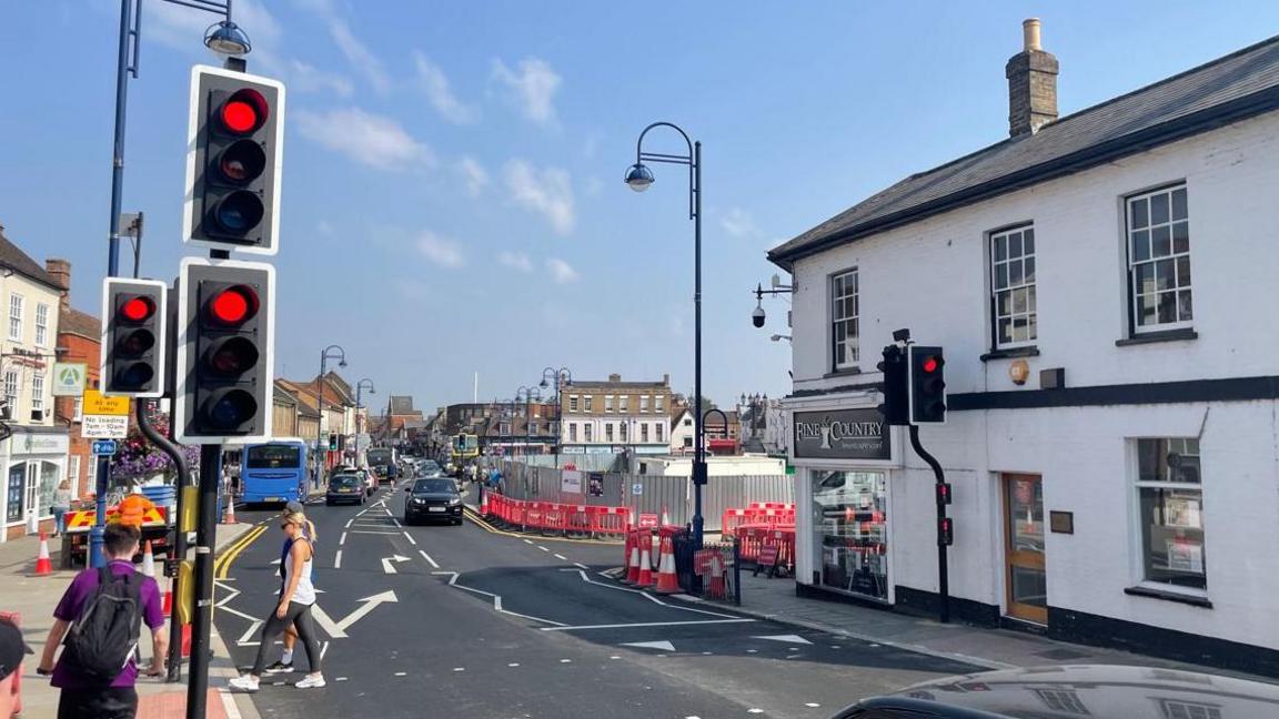 A general street view of St Neots, showing people crossing a road